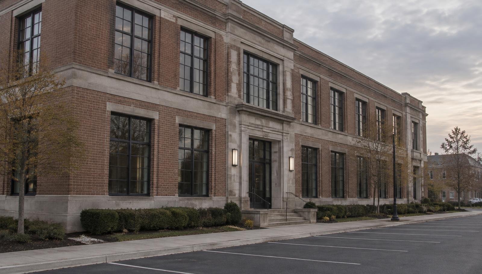 A two-story brick and limestone commercial building with an empty parking row
